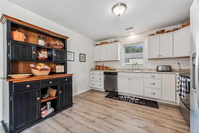 kitchen featuring light hardwood / wood-style flooring, sink, stainless steel appliances, light stone countertops, and white cabinetry