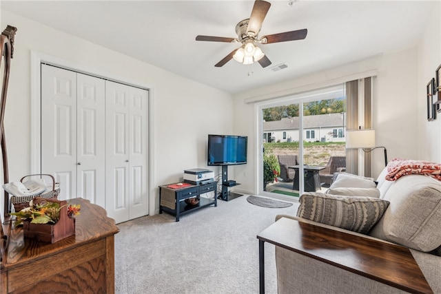 living room with ceiling fan and carpet