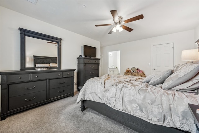 bedroom with ceiling fan, connected bathroom, and light carpet