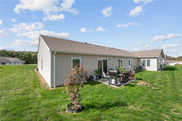 rear view of house featuring central AC, a yard, and a patio area