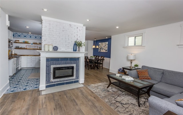 living room with light hardwood / wood-style floors and a tiled fireplace