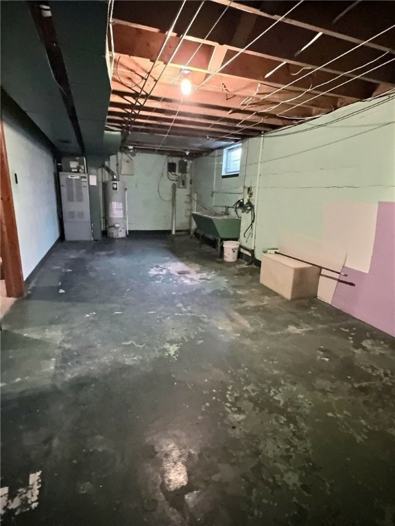 basement featuring water heater, heating unit, and sink