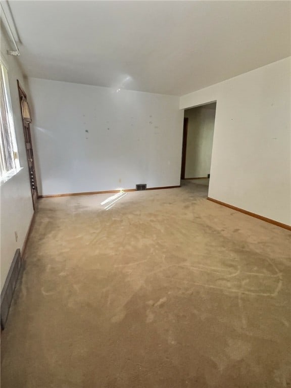 unfurnished room featuring light carpet