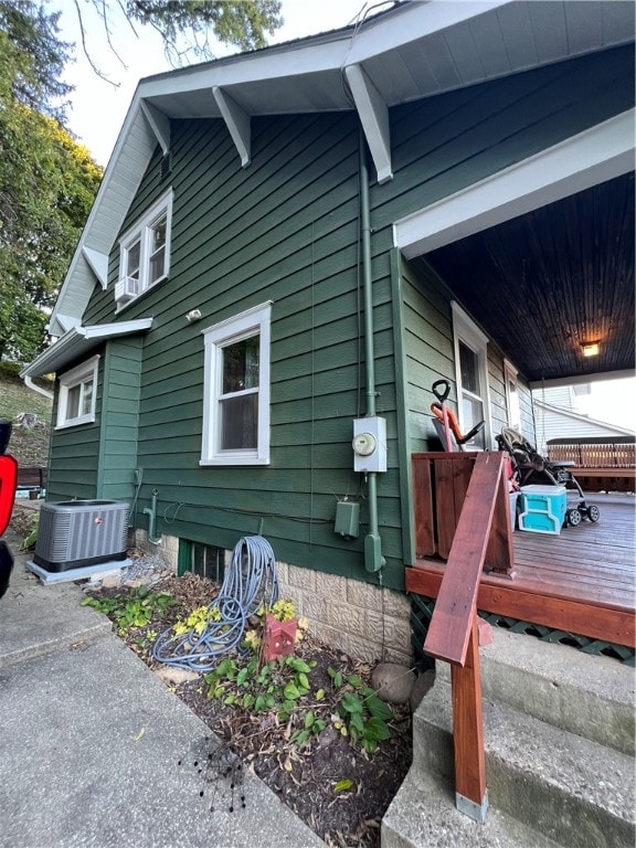 view of property exterior with a deck and central air condition unit