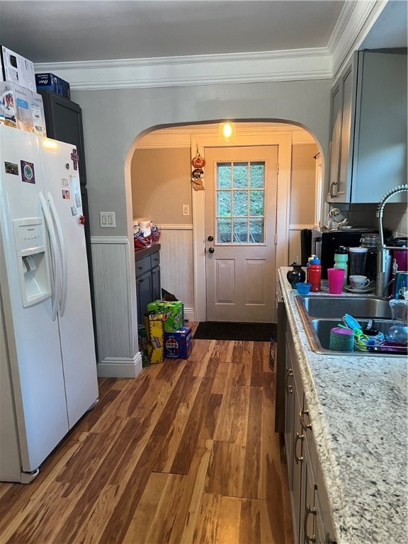 kitchen with white fridge with ice dispenser, dark wood-type flooring, sink, crown molding, and gray cabinets