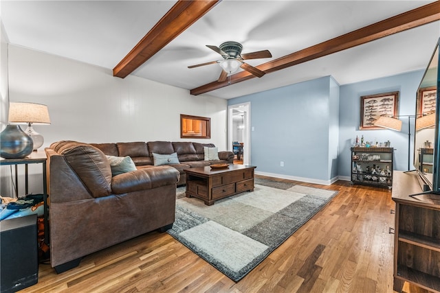 living room featuring beamed ceiling, hardwood / wood-style floors, and ceiling fan