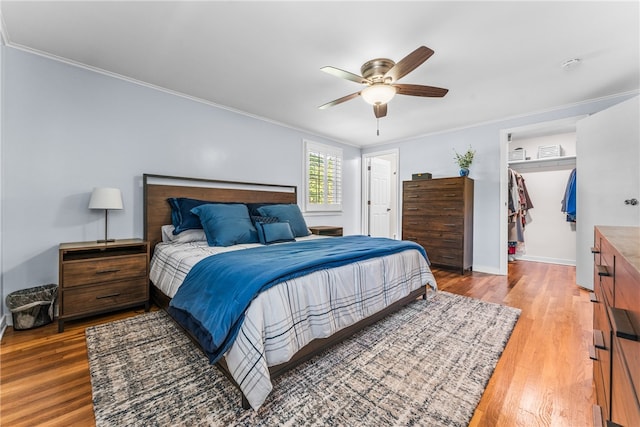 bedroom featuring a closet, hardwood / wood-style floors, ornamental molding, and ceiling fan