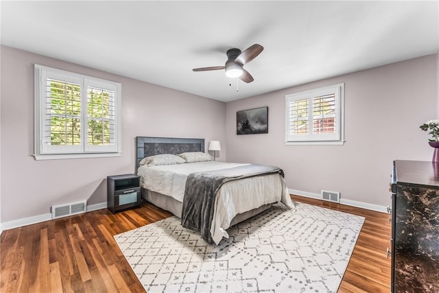 bedroom with ceiling fan and dark hardwood / wood-style flooring