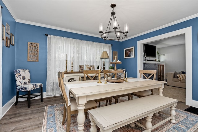 dining room with crown molding, hardwood / wood-style floors, and a chandelier