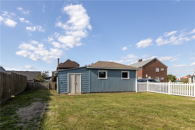 back of property featuring a yard and a shed