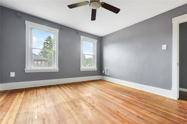 spare room featuring ceiling fan, light hardwood / wood-style flooring, and a healthy amount of sunlight