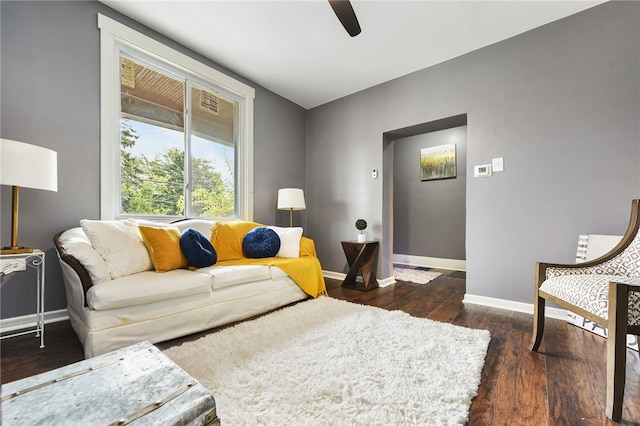 living room with dark wood-type flooring and ceiling fan