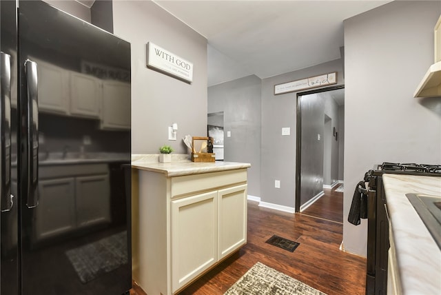 kitchen with stainless steel range with gas stovetop and dark hardwood / wood-style floors