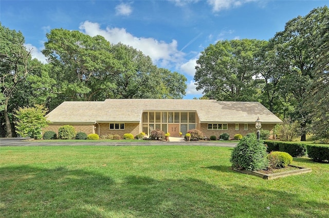 ranch-style home with a front yard and a sunroom