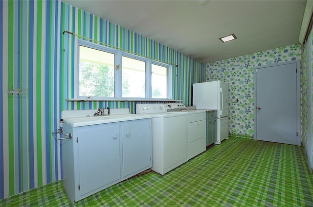 laundry area with independent washer and dryer, cabinets, and sink