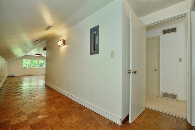 corridor featuring baseboards, electric panel, and vaulted ceiling