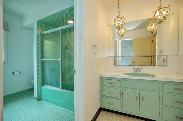 bathroom featuring toilet, vanity, shower / bath combination with glass door, baseboards, and tile patterned floors