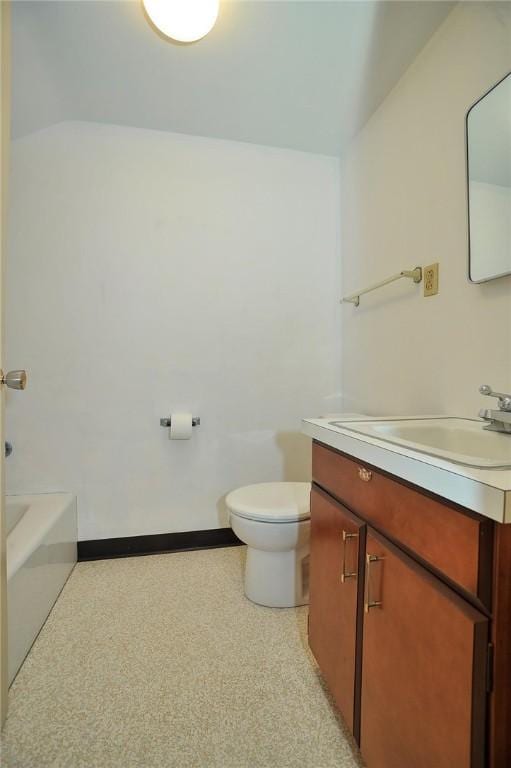 full bath featuring toilet, vanity, a tub, and vaulted ceiling