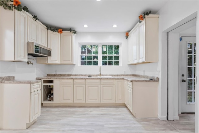 kitchen featuring light hardwood / wood-style flooring, cream cabinets, and sink