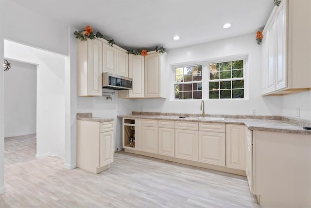 kitchen featuring sink, cream cabinetry, and light hardwood / wood-style floors