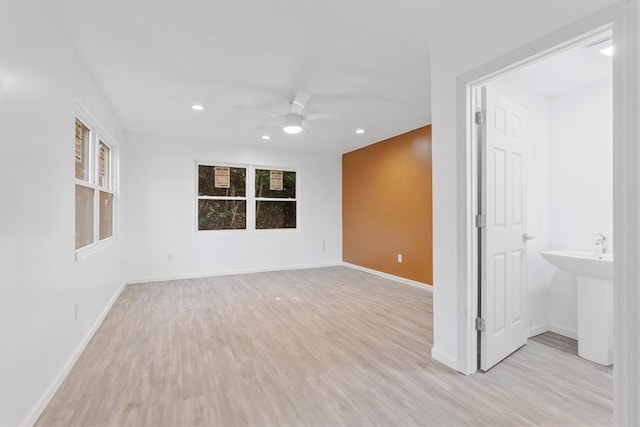 spare room with light wood-type flooring and ceiling fan