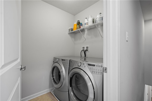 laundry area featuring washer and clothes dryer and light tile patterned floors