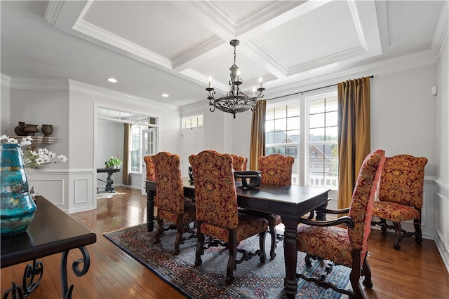 dining room featuring wood-type flooring, an inviting chandelier, crown molding, and coffered ceiling