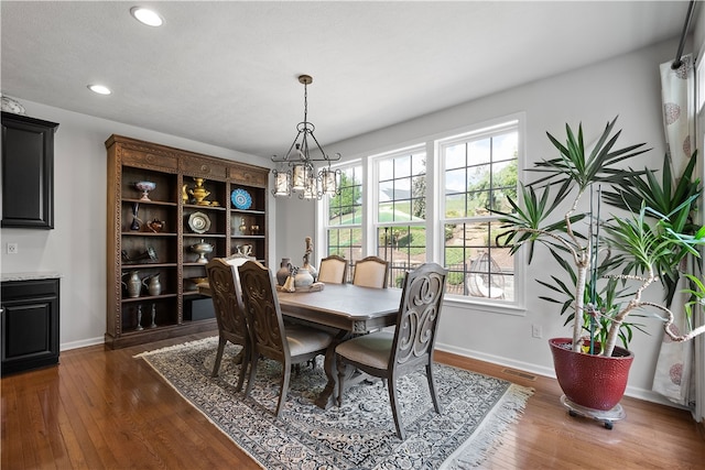 dining area with an inviting chandelier and dark hardwood / wood-style flooring