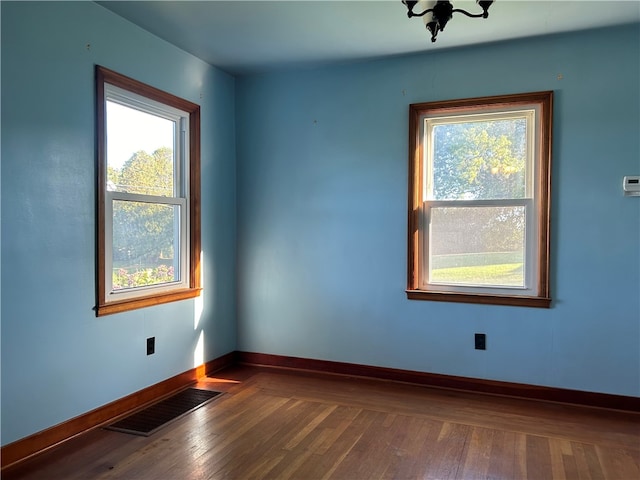 unfurnished room with dark wood-type flooring