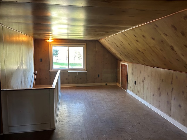 additional living space with wood walls and vaulted ceiling