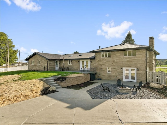 1205 Curry Rd, Sewickley Twp, PA 15083 - rear view of property featuring french doors, a fire pit, a patio, a chimney, and stone siding