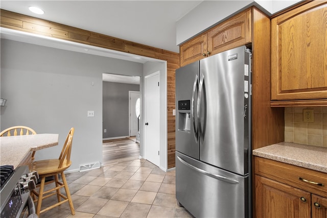 kitchen with backsplash, stainless steel appliances, and light tile patterned flooring