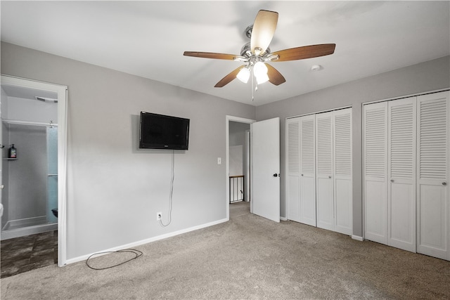 unfurnished bedroom with two closets, light carpet, ensuite bathroom, and ceiling fan