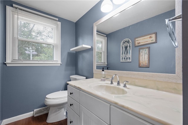 bathroom with toilet, hardwood / wood-style flooring, and vanity