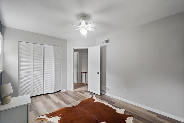 unfurnished bedroom featuring light hardwood / wood-style floors, a closet, and ceiling fan