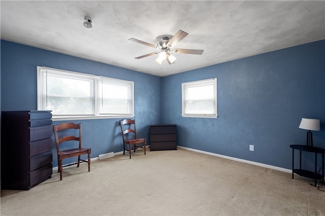 sitting room featuring light carpet and ceiling fan