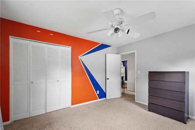 unfurnished bedroom featuring light carpet, a closet, and ceiling fan