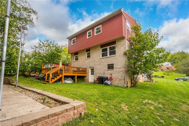 rear view of house featuring a deck and a lawn