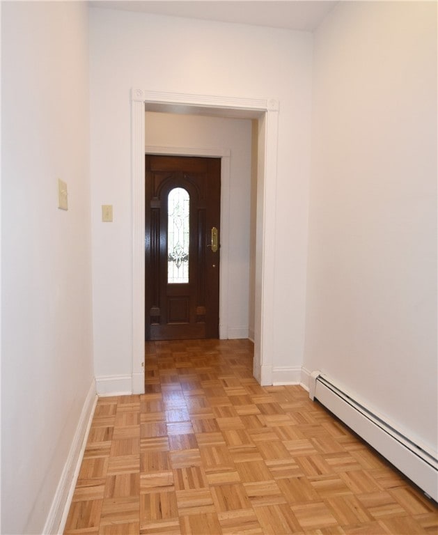 doorway featuring baseboard heating and light parquet flooring