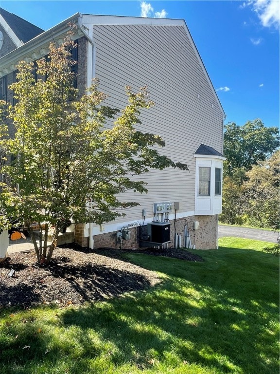 view of home's exterior featuring a lawn and central AC unit