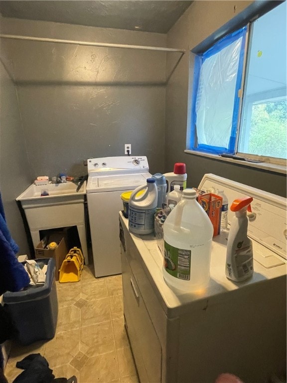 laundry area with separate washer and dryer and light tile patterned flooring