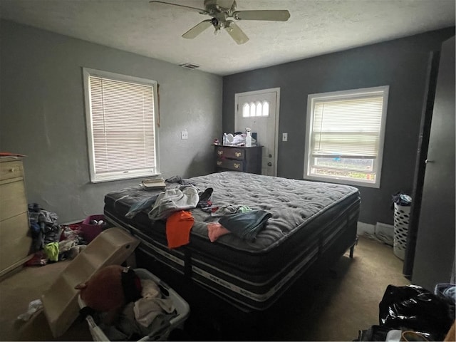 carpeted bedroom with a textured ceiling and ceiling fan