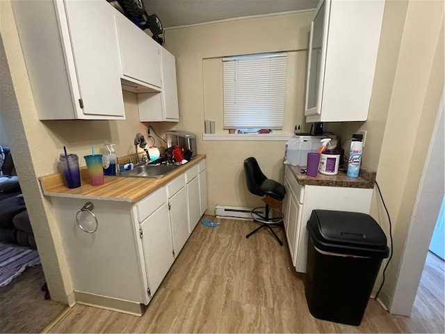 kitchen with white cabinets, sink, and light hardwood / wood-style floors