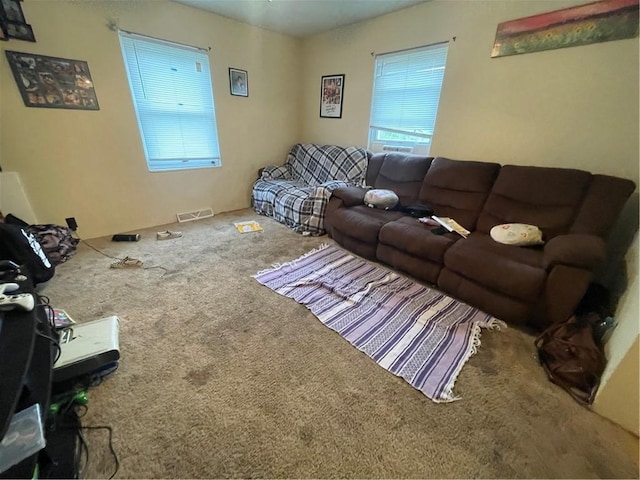 living area with visible vents and carpet