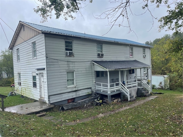 back of house featuring a porch, cooling unit, and a lawn