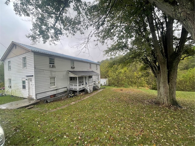 rear view of property featuring a lawn