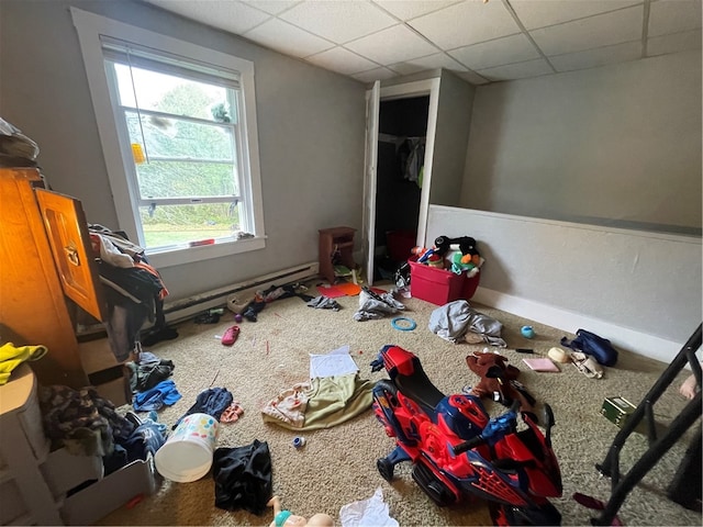 rec room featuring a drop ceiling, a baseboard radiator, and carpet flooring