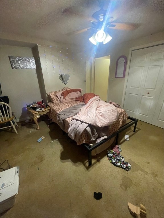 bedroom with ceiling fan, a closet, carpet, and a textured ceiling