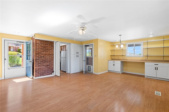 kitchen with a wealth of natural light, stainless steel refrigerator, and light hardwood / wood-style floors