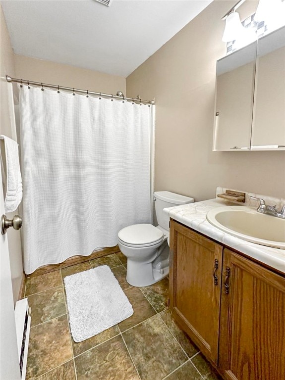 bathroom with a shower with shower curtain, a baseboard heating unit, vanity, and toilet